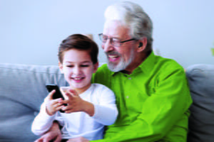 An elderly man with a kid cuddled up, representing the hearing loss in the US.