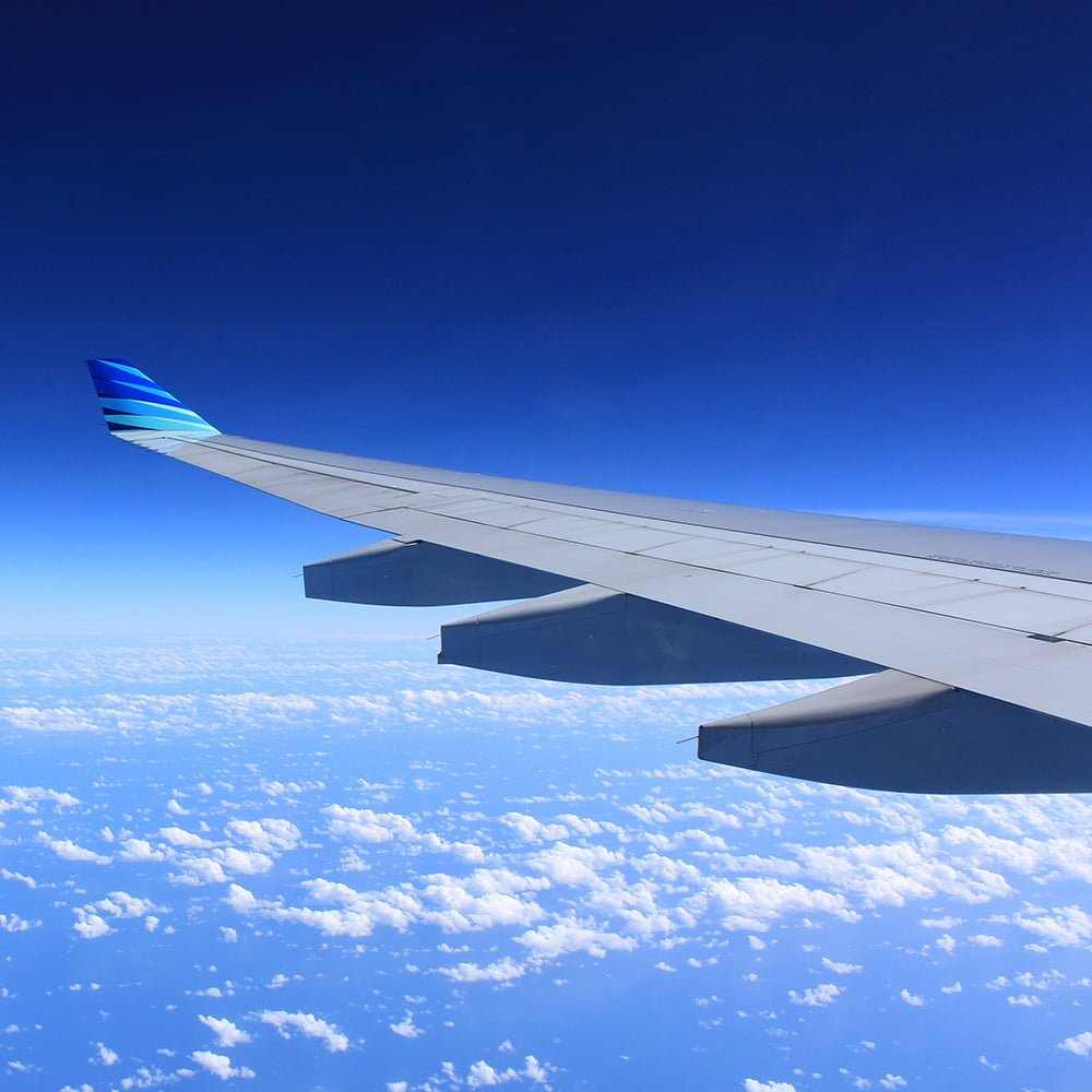 Plane wing above clouds illustrating the altitude and ear pressure it would create.