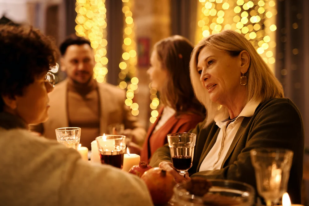 A senior woman participating in conversation during family dinner trying to hear in noisy environments.